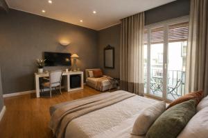 a bedroom with a bed and a desk and a television at Maxim in Palermo