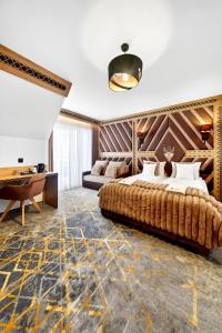 a bedroom with a large bed and a desk at Grand Regle Resort & SPA in Poronin
