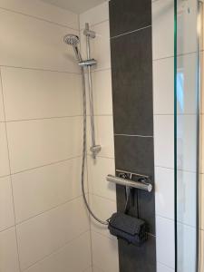 a shower in a bathroom with a glass door at Ferienhaus Helmshuus in Leer +19 photos