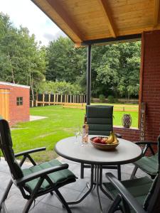 a table with a bowl of fruit on a patio at Ferienhaus Helmshuus in Leer