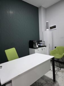 an office with a white table and two green chairs at Aybek Ratio Hotel in Çanakkale