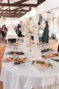 a long white table with plates of food on it at Hotelli Lepolampi in Espoo