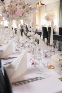 a long table with wine glasses and flowers on it at Hotelli Lepolampi in Espoo +24 photos