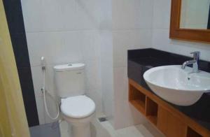 a bathroom with a white toilet and a sink at Nina Hotel Syariah in Salatiga