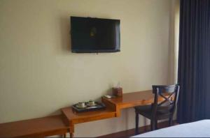 a room with a desk with a television on the wall at Nina Hotel Syariah in Salatiga +18 photos