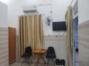 a room with two chairs and a table and a fan at Motel Khánh Vy in Bảo Lộc +25 photos