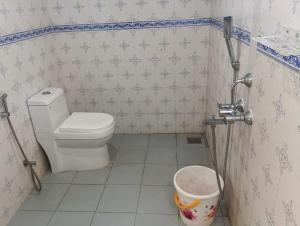 a small bathroom with a toilet and a bucket at Ocean Queen Palace Kovalam in Trivandrum