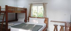 a bedroom with two bunk beds and a window at Vaplanakhaw Ubon in Ubon Ratchathani