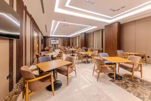 ein Esszimmer mit Holztischen und Stühlen in der Unterkunft Grand hotel alhamra in Dschidda