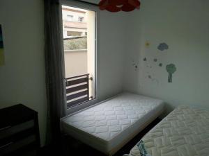 Dormitorio con ventana y cama al lado en Cote Sud, en Mauguio