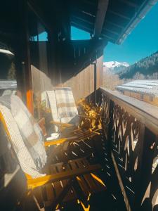 two chairs on a balcony with a view of mountains at Exceptional Duplex, Cozy & Authentic Atmosphere in Les Gets