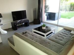 sala de estar con sofá y TV en Cote Sud, en Mauguio