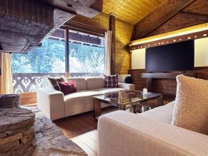 a living room with a couch and a flat screen tv at Exceptional Duplex, Cozy & Authentic Atmosphere in Les Gets