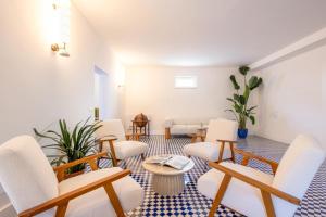 a living room with white chairs and a table at Villa Bellarosa in Sorrento