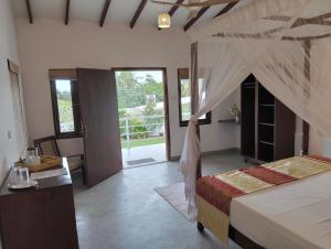 a bedroom with a bed with a mosquito net at White House Tangalle in Tangalle