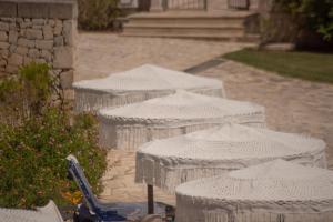 a row of white umbrellas on a sidewalk at Basiliani - CDSHotels in Otranto