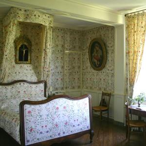 a bedroom with a bed with floral wallpaper and a table at Manoir de Villers in Saint-Pierre-de-Manneville