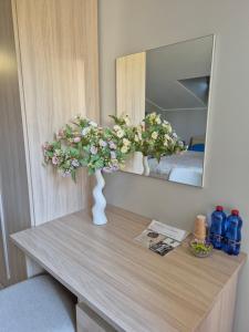 a table with a vase with flowers on it in front of a mirror at Tenuta Albachiara in Naso +32 photos