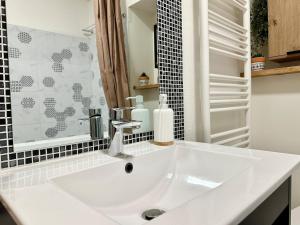 a white sink in a bathroom with a mirror at Le Bohème - hyper centre - cosy in Mont-de-Marsan