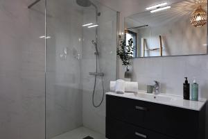 a bathroom with a shower and a sink and a mirror at I Salini - T3 élégant & calme près du centre - Classé 4 étoiles in Porto-Vecchio +25 photos