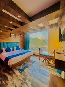 a bedroom with a bed and a large window at Hotel Royal Orbit By Arony Hospitality Dehradun in Dehradun