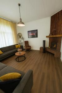 a living room with a couch and a fireplace at Groepsverblijf Villa d'Uylenburgh in Hommerts