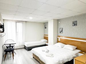 a room with two beds and a table and a chair at Avcılar İnci Hotel in Istanbul