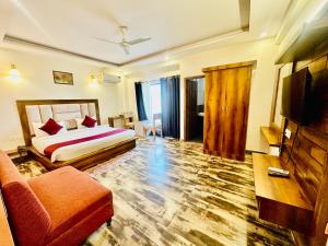 a hotel room with a bed and a couch at Hotel Royal Orbit By Arony Hospitality Dehradun in Dehradun