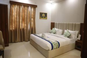 a bedroom with a large bed and a window at AmarVandana Palace in Rādha Kund
