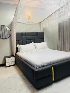 a bed with a black headboard in a bedroom at Luxury homes ug in Kampala