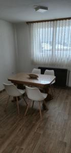 a dining room with a table and white chairs at Center Heritage Apartment in Teslić