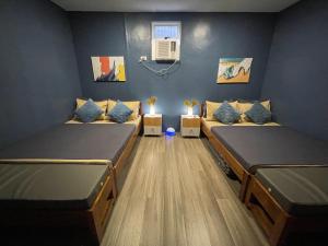 a room with two beds in a room at Balai Evelyn Homestay in Coron