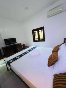 a bedroom with a large white bed in a room at Nature's Edge Udawalawa in Sinuggala