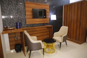 a room with two chairs and a tv on a wall at AmarVandana Palace in Rādha Kund +29 photos