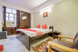 a hotel room with a bed and a chair at Hotel O Kamini in Patna +30 photos
