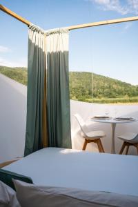 a bed and a table in a room with a window at Bulle à la Belle étoile in Clécy +1 photo