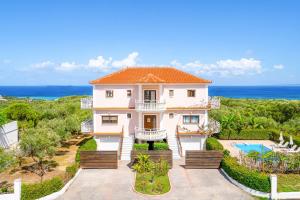 a large white house with a view of the ocean at Villa Zante Odysseus in Planos