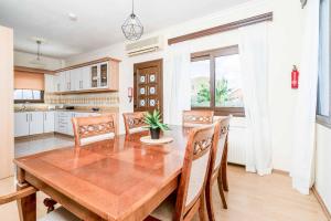 a dining room with a wooden table and chairs at Villa Zante Odysseus in Planos