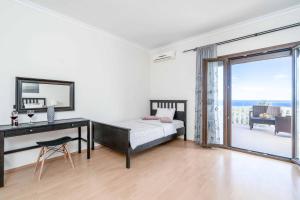 a bedroom with a bed and a desk and a window at Villa Zante Odysseus in Planos +18 photos