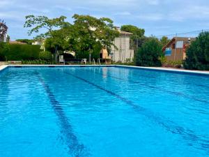 a large swimming pool with blue water at Stil Mar Anna Terra - by Apartamentos Stil Mar Anna in L'Escala