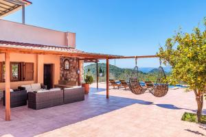 an outdoor patio with chairs and hammocks on a house at Villa Terracotta in Alikias