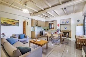 a living room with couches and a table and a kitchen at Villa Terracotta in Alikias