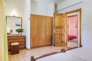 a bedroom with a bed and a dresser and a mirror at Villa Terracotta in Alikias +44 photos