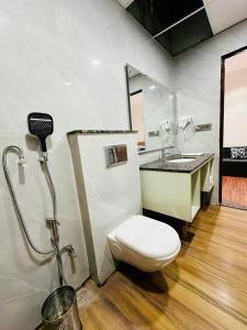 a bathroom with a toilet and a sink at Hulara Meadows in Lucknow