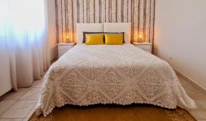 a bedroom with a white bed with two yellow pillows at Casa Lu in Salir de Porto