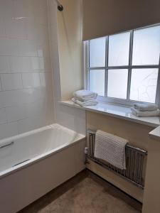 ein Badezimmer mit Badewanne und Fenster in der Unterkunft Ecclefechan Hotel in Ecclefechan + 42 Fotos
