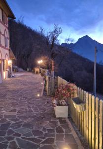 a fence and a stone walkway next to a house at Dimora del Serva in Belluno