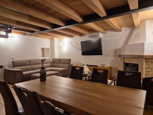 a room with a table and chairs and a television at Dimora del Serva in Belluno