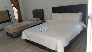 a bedroom with two beds with towels on them at Makok Seaview roomstay in Kampung Penarik