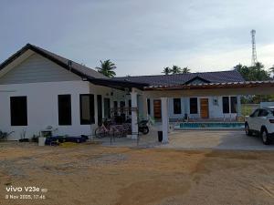 a house with a car parked in front of it at Makok Seaview roomstay in Kampung Penarik